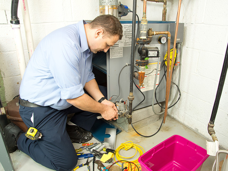 hvac technician at property interiors repairing gas furnace collinsville il